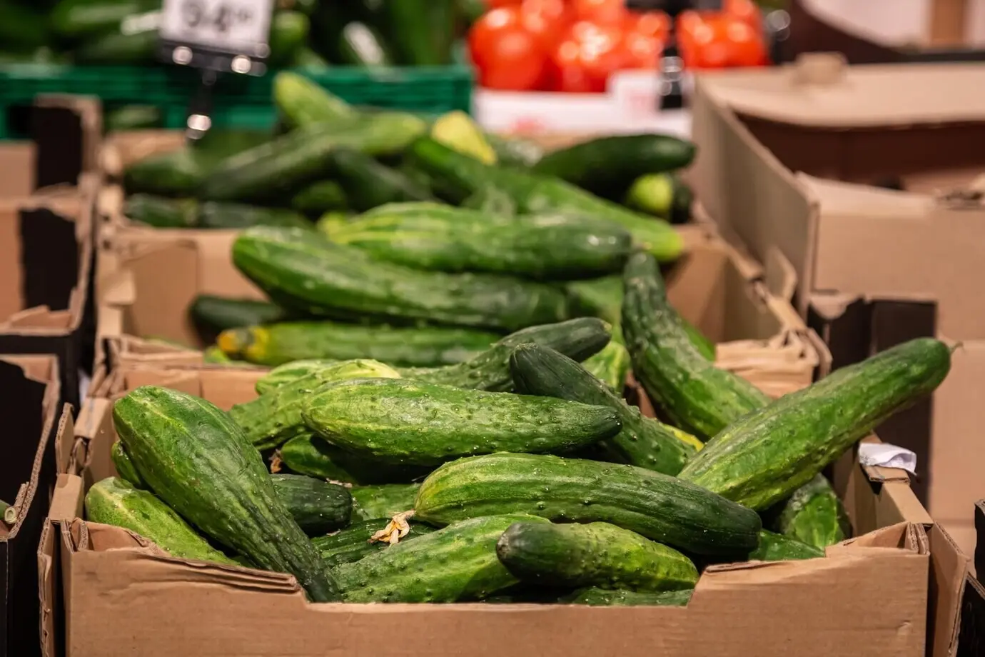 Свежий огурец в коробке продаётся в овощном продуктовом магазине.